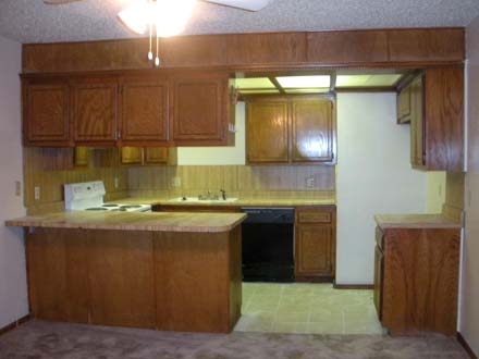 A large kitchen with stainless steel appliances and wooden cabinets
