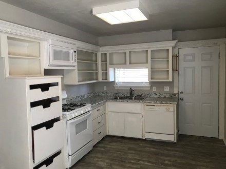 A kitchen with a stove and a refrigerator