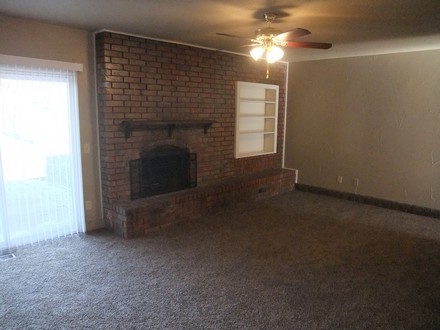 Living room with ceiling fan and fireplace
