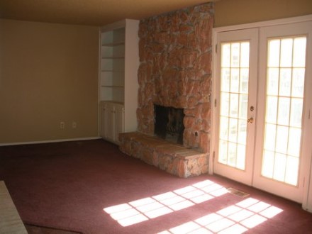 A room with a fireplace near a window
