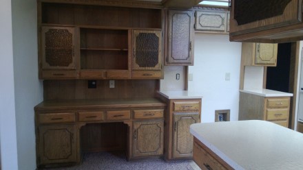 A kitchen with wooden cabinets and a microwave