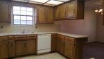 A kitchen with wooden cabinets and a window